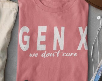 Pode incluir: Uma camiseta rosa com o texto "GEN X we don't care" em letras brancas.