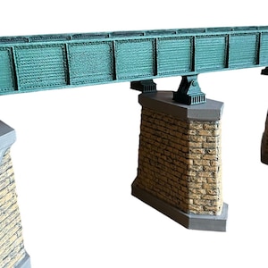 May include: A model train bridge with a green metal structure and stone supports. The bridge is made of plastic and is designed for use with model trains.