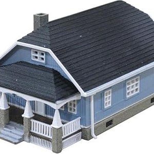 May include: A miniature blue house with a dark gray roof, white trim, and a front porch. The house has a chimney and small windows. The porch has white railings and gray pillars. A model home for a dollhouse or train set.
