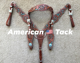 Puede incluir: Un juego de guarnicionería para caballos de cuero marrón con detalles turquesa y tallas florales. El juego incluye cabezada, petral y riendas. El texto "American Tack" se muestra en blanco.