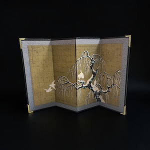 Puede incluir: Un biombo decorativo con fondo dorado y una detallada ilustración de un árbol y pájaros. La pantalla tiene un marco negro con detalles dorados en las esquinas. La obra de arte es de estilo tradicional japonés.