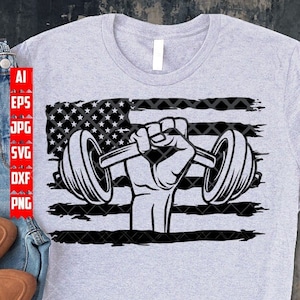 Könnte beinhalten: Ein graues T-Shirt mit einem schwarzen und weißen, abgenutzten amerikanischen Flaggen-Design, das eine Hand zeigt, die eine Langhantel hebt.
