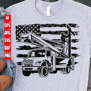 May include: Light gray t-shirt featuring a black and white graphic of a utility truck with a bucket lift, set against a stylized American flag. The design includes the text "AI, EPS, JPG, SVG, DXF, PNG" on the left side.