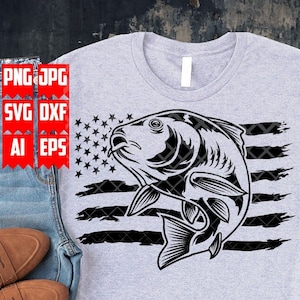 May include: A black and white graphic design of a fish jumping out of the water with an American flag behind it. The fish is in a distressed style and the flag is in a distressed style. The design is on a grey t-shirt.