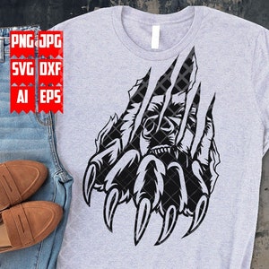 May include: A black and white graphic design of a bear claw ripping through a surface. The claw is detailed with sharp points and the bear's face is visible in the background.