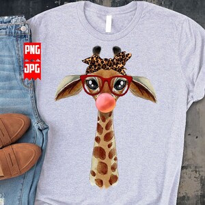 May include: A gray t-shirt with a watercolor illustration of a giraffe wearing red glasses and a leopard print headband. The giraffe has a pink bubble sticking out of its mouth.