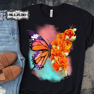 Puede incluir: Una camiseta negra con una mariposa colorida y rosas naranjas sobre un fondo de acuarela.