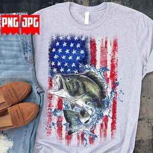 May include: A light gray t-shirt featuring a distressed American flag design with a leaping fish graphic. The flag incorporates red and white stripes with blue stars. The fish is depicted with water splashes.