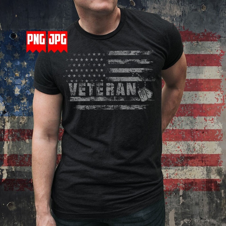 May include: Dark gray t-shirt featuring a distressed American flag design with the word "VETERAN" in white block letters. The shirt includes a dog tag graphic. The background shows a faded American flag.