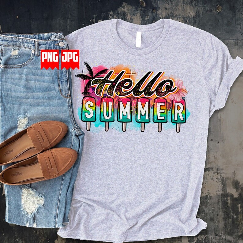 May include: A light gray t-shirt with the words "Hello Summer" in a colorful design. The design includes popsicle illustrations and tropical elements. The shirt is paired with blue denim jeans and brown loafers.