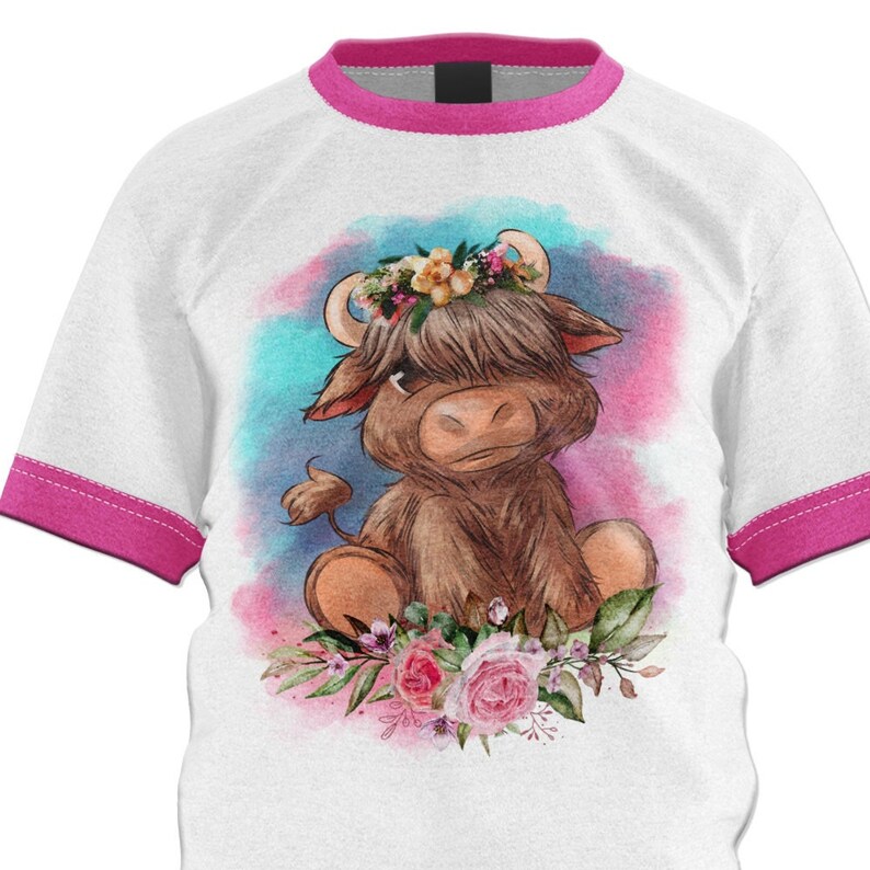 May include: A white t-shirt with a pink ringer design features a watercolor illustration of a brown Highland cow wearing a flower crown. The cow is sitting on a bed of pink and white flowers.