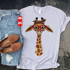 May include: A gray t-shirt with a watercolor illustration of a giraffe wearing red glasses and a leopard print headband. The giraffe is looking directly at the viewer.