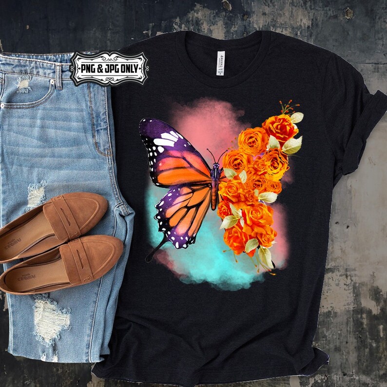 Puede incluir: Una camiseta negra con una mariposa colorida y rosas naranjas sobre un fondo de acuarela.