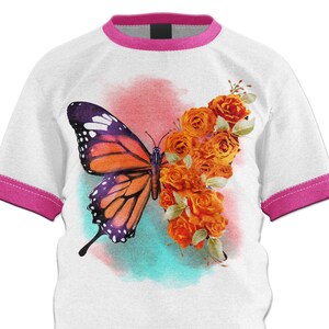 Puede incluir: Una camiseta blanca con un ribete rosa, que presenta un dise&ntilde;o de acuarela de una mariposa y rosas naranjas.