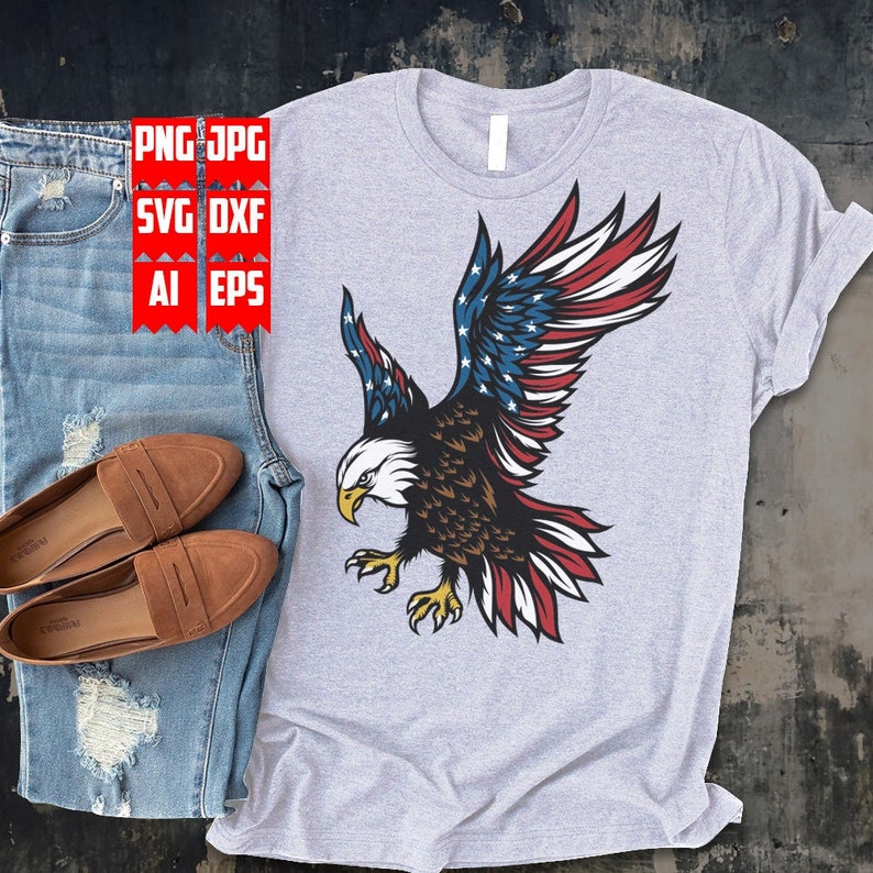 May include: A gray t-shirt with a graphic of a bald eagle with its wings spread. The eagle's wings are decorated with the American flag.