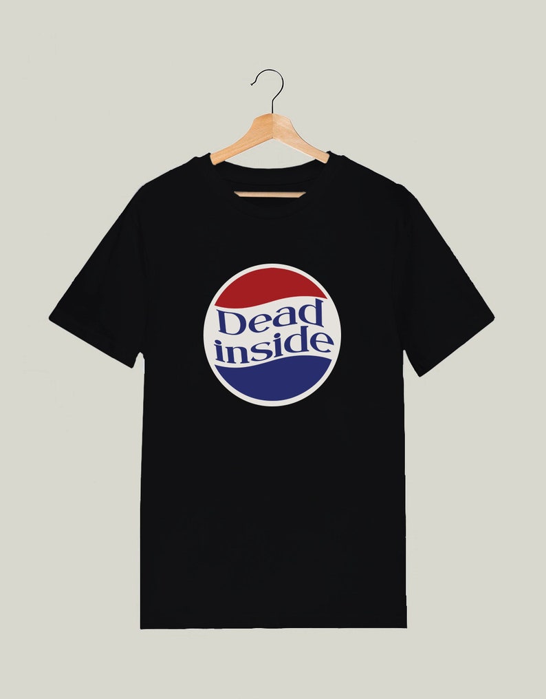 May include: Black t-shirt with a white circle graphic featuring the text "Dead inside" in blue and red lettering. The graphic resembles a soda can logo.