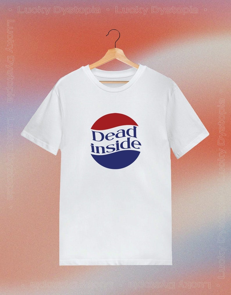 May include: White t-shirt with a blue and red logo that says "Dead inside" in a retro font.