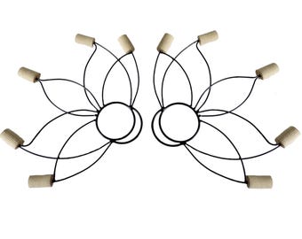May include: Two sets of fire dancing props, each featuring a central black ring with radiating black wires. Each wire connects to a cylindrical, beige-colored wick. The props are designed for performance and are set against a white background.