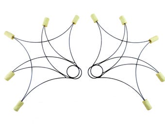 May include: Two symmetrical fire poi, a prop for fire dancing. Each poi features a black wire frame with a circular handle and six cream-colored wicks. The wicks are attached to the frame by thin black wires.