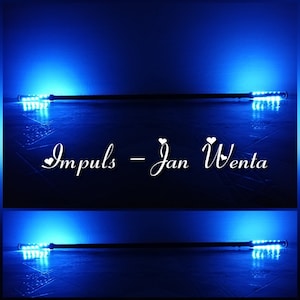 Pode incluir: Dois bastões de luz LED pretos com luzes azuis acesas. Os bastões estão sobre uma superfície azul com um fundo branco. O texto "Impuls - Jan Wenta" está escrito em branco sobre a superfície azul.