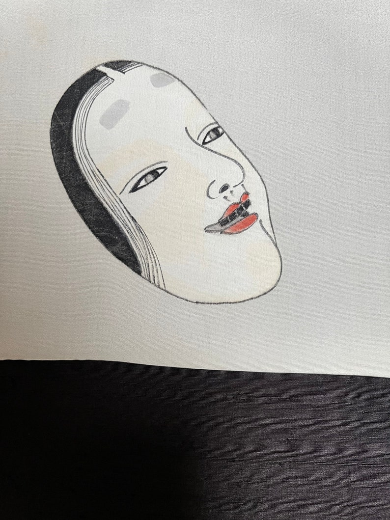 K&ouml;nnte beinhalten: Eine Schwarzwei&szlig;illustration einer japanischen Noh-Maske mit rotem Mund und wei&szlig;em Gesicht. Die Maske befindet sich auf einem wei&szlig;en Hintergrund.