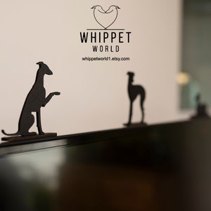 Pode incluir: Duas figuras de c&atilde;o Whippet em silhueta preta em cima de uma televis&atilde;o preta. O texto "Whippet World" est&aacute; acima das figuras.