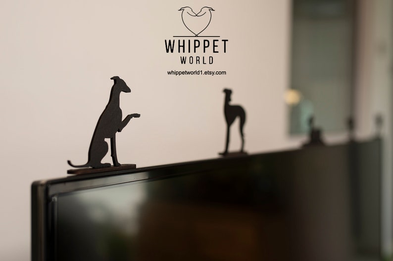 Pode incluir: Duas figuras de c&atilde;o Whippet em silhueta preta em cima de uma televis&atilde;o preta. O texto "Whippet World" est&aacute; acima das figuras.