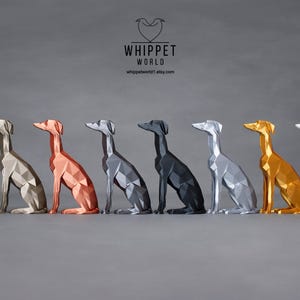 Könnte beinhalten: Eine Reihe von neun Whippet-Hundefiguren in verschiedenen Metallic-Farben, darunter Silber, Gold, Kupfer und Schwarz. Die Figuren sitzen alle mit erhobenem Kopf. Das Whippet World Logo ist oben im Bild zu sehen.