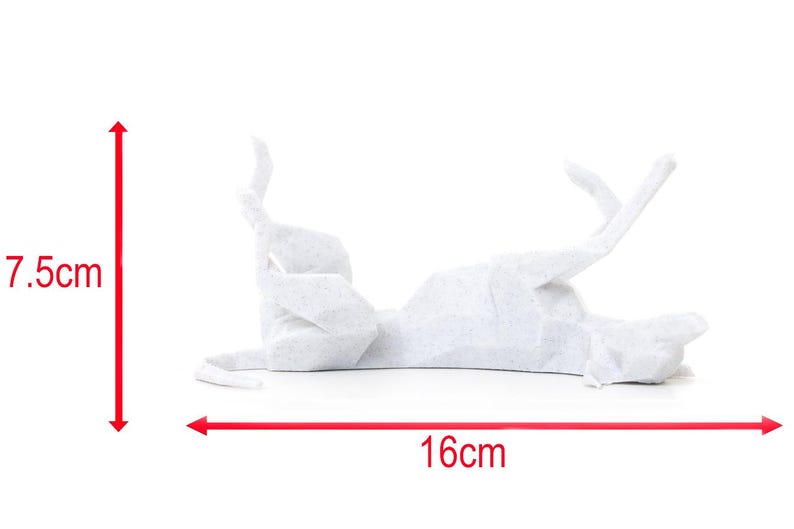 K&ouml;nnte beinhalten: Eine wei&szlig;e Origami-Katze, die auf dem R&uuml;cken liegt, mit den Pfoten in der Luft. Die Papierkatze ist 16 cm lang und 7,5 cm hoch. Die Katze hat ein dezentes Muster aus kleinen grauen Punkten. Der Hintergrund ist wei&szlig;.