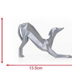 K&ouml;nnte beinhalten: Eine silberne, geometrische Hundeskulptur. Der Hund befindet sich in einer nach unten gerichteten Pose und misst 8 cm in der H&ouml;he und 13,5 cm in der L&auml;nge. Die Skulptur hat ein modernes, minimalistisches Design, geeignet f&uuml;r die Inneneinrichtung.