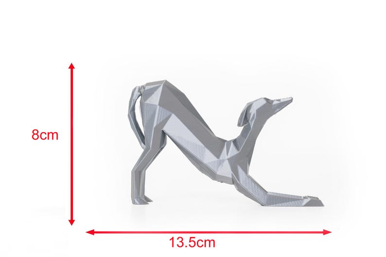 K&ouml;nnte beinhalten: Eine silberne, geometrische Hundeskulptur. Der Hund befindet sich in einer nach unten gerichteten Pose und misst 8 cm in der H&ouml;he und 13,5 cm in der L&auml;nge. Die Skulptur hat ein modernes, minimalistisches Design, geeignet f&uuml;r die Inneneinrichtung.