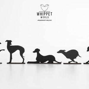 Pode incluir: Cinco figuras de silhueta preta de c&atilde;es Whippet em diferentes poses. As silhuetas est&atilde;o sobre um fundo branco. O texto "Whippet World" est&aacute; na parte superior da imagem.