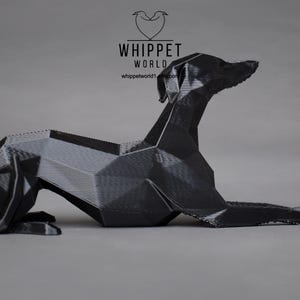 May include: A black, 3D printed sculpture of a whippet dog in a lying down position. The sculpture is made up of geometric shapes and has a textured surface.