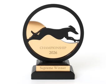 Op de afbeelding: Een ronde trofee met een zwart silhouet van een rennende windhond tegen een gouden achtergrond. Het gouden gedeelte is gegraveerd met de tekst CHAMPIONSHIP 2026. De voet is zwart met een gouden plaatje met de tekst Supreme Winner.