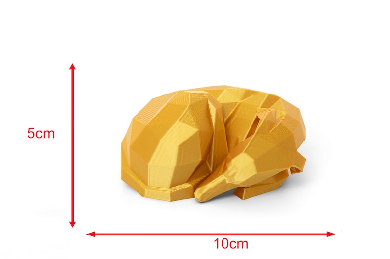 K&ouml;nnte beinhalten: Eine geometrische, goldgelbe Skulptur eines schlafenden Hundes. Die Hundefigur ist etwa 10 cm lang und 5 cm hoch. Das Design weist scharfe Winkel und Facetten auf, was ihm eine moderne, minimalistische &Auml;sthetik verleiht. Der Hund ist zusammengerollt und wirkt friedlich.