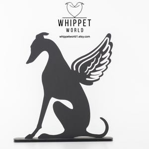 Op de afbeelding: Zwart metalen silhouet van een whippet-hond met engelen vleugels, zittend op een zwarte basis. De afbeelding bevat de tekst "WHIPPET WORLD" en het websiteadres whippetworld1.etsy.com.
