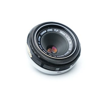 May include: A set of three ceramic mugs with a speckled, matte finish. The mugs are in shades of cream, light gray, and dark gray. Each mug has a simple, minimalist design and a rounded handle.