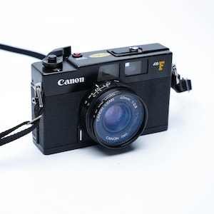 Vintage canon a35f camera, 1978 rangefinder with 40mm lens, auto exposure, built-in flash, includes kodak film, retro point and shoot