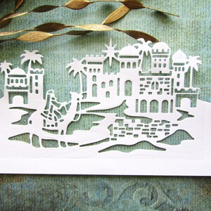 Papier découpé paysage de Nazareth blanc, kasbahs blanches, étoile directrice, naissance de Jésus, oasis du désert, création artisanale, fabrication de cartes