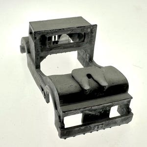 Pode incluir: Um chassi de caminh&atilde;o modelo de pl&aacute;stico cinza com uma cabine detalhada e um engate. O modelo n&atilde;o tem rodas nem carroceria.