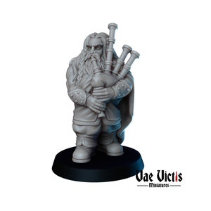 Pode incluir: Uma figura miniatura pintada de cinza de um anão tocando gaita de foles. O anão está vestindo uma capa longa e fluida e tem barba. A gaita de foles tem vários tubos e é segurada nas mãos do anão. A figura está em pé sobre uma base preta com as palavras "Vae Victis - Miniatures" impressas nela.