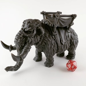 May include: A grey, furry, miniature mammoth figurine with a saddle and a rope harness. The mammoth has a metal face mask and tusks. The figurine is on a white background.