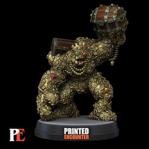 Op de afbeelding: Een gouden miniatuurfiguur van een wezen gemaakt van munten, met een kroon op en een schatkist vasthoudend. Het figuur staat op een zwarte basis met de tekst "PRINTED ENCOUNTER" erop.