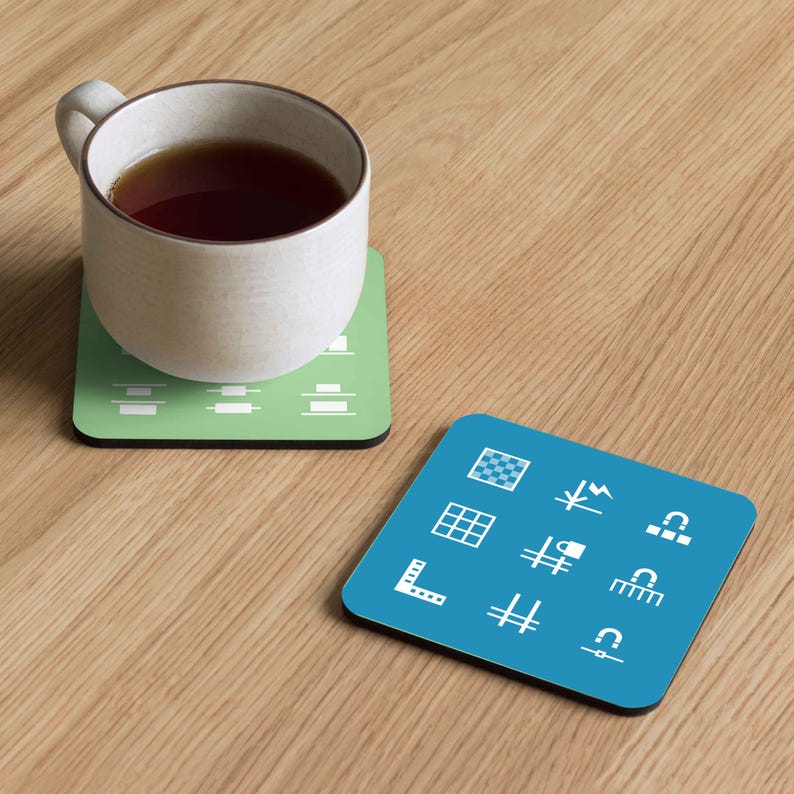May include: Two square coasters with geometric designs. One is light green with white horizontal lines, and the other is blue with white icons. A white mug with tea sits on the green coaster.