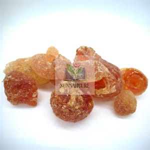 May include: A selection of amber-hued, irregularly shaped pieces, possibly resin or a similar material. The pieces vary in size and have a translucent appearance, with some areas more opaque. The image includes the text "SUNNAHCURE".