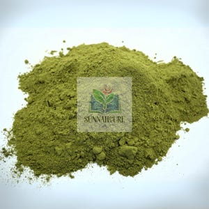 May include: A pile of finely ground, green powder. The powder is a vibrant green color and appears to be a natural product. The image includes a watermark with the text "SUNNAHCURE" and a logo featuring a book and leaves.