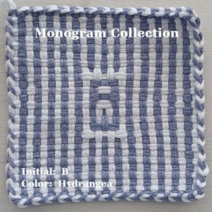 May include: A square woven potholder featuring a blue and white checkered pattern with a central letter B monogram. The text Monogram Collection, Initial: B, and Color: Hydrangea are printed on the surface. The edges are finished with a braided border.