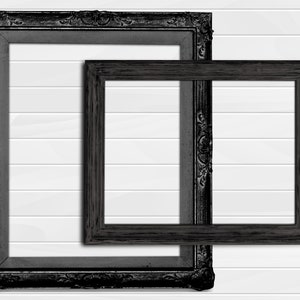 May include: Two black picture frames, one inside the other, against a white wood panel background. The larger frame has a more ornate design.