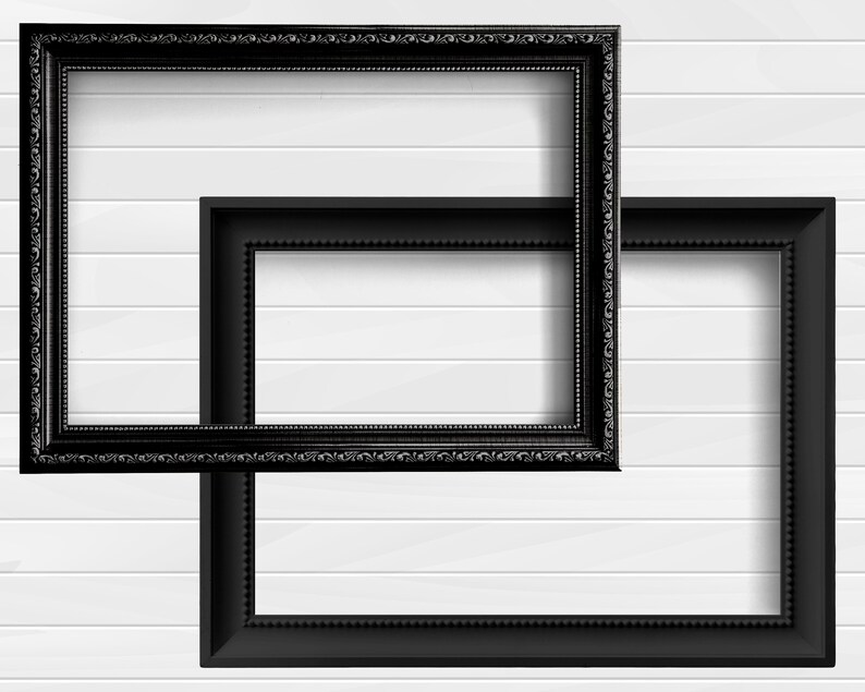 May include: Two black picture frames, one slightly larger than the other, are positioned on a white wood panel wall. The frames are both ornate with a decorative border.