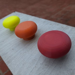 Peut inclure: Trois boutons ronds en plastique de couleurs différentes. Les boutons sont jaune, orange et rouge. Les boutons sont disposés en rangée de gauche à droite.